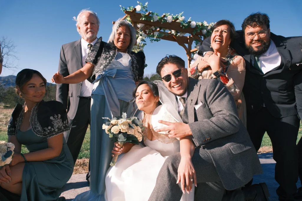 Couple laughing with family and friends at their wedding